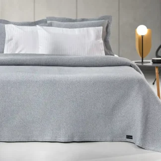 Ανοιξιάτικη κουβέρτα Slalom Anthracite της εταιρίας Guy Laroche Paris. Μονόχρωμη, jacquard, κατασκευασμένη από 60% βαμβάκι και 40% polyester, 180 x 260 εκατοστά.