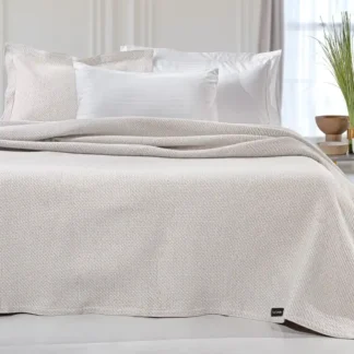 Ανοιξιάτικη κουβέρτα Slalom Ivory της εταιρίας Guy Laroche Paris. Μονόχρωμη, jacquard, κατασκευασμένη από 60% βαμβάκι και 40% polyester, 180 x 260 εκατοστά.